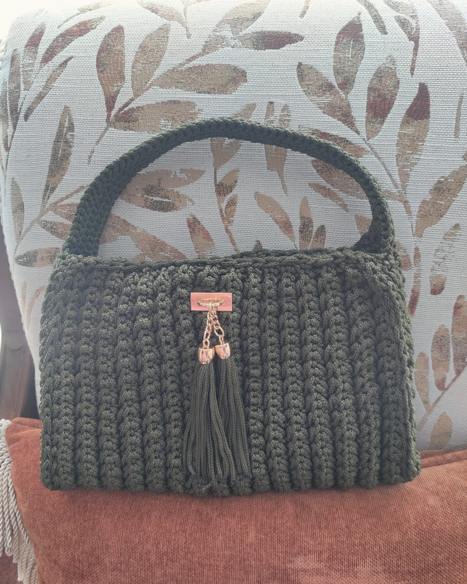 Bolso tejido verde olivo con asa tejida, broche dorado y borla