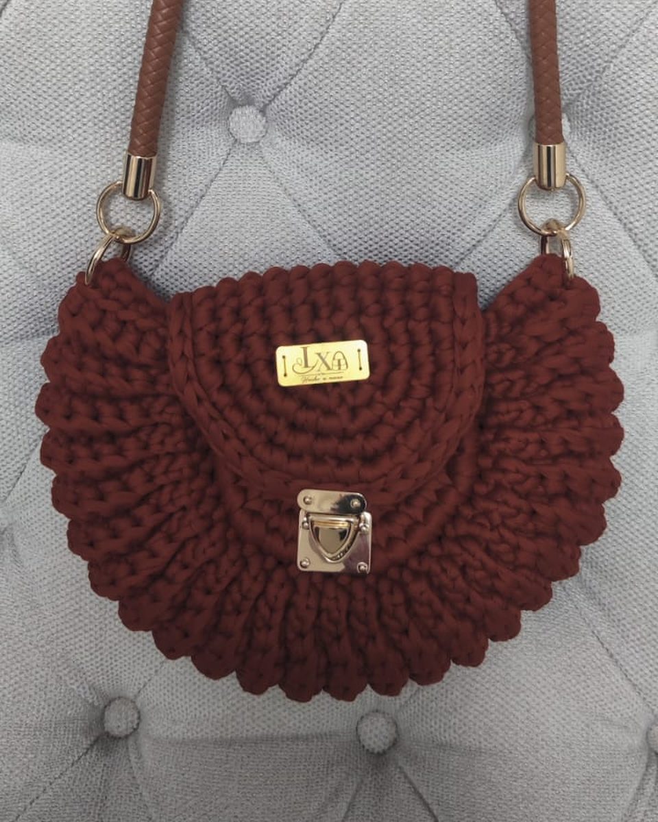 Bolso tejido color terracota con solapa redonda, asa trenzada café y cierre metálico